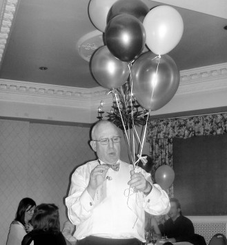 Picture from the Winter Ball of someone holding six helium filled ballons.
