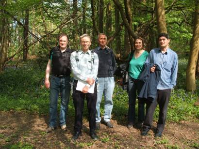 5 members of the group pose in a clearing in the woods