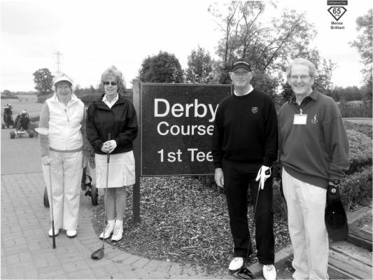 Mary stands, driver in hand, with her playing partners, next to a sign announcing the first tee of the Derby course.