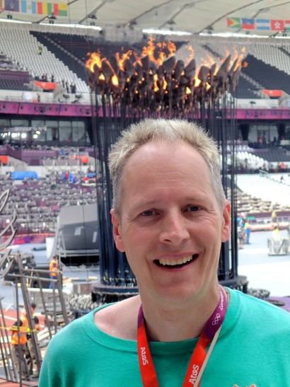 Neil with the Olympic cauldron alight behind him.