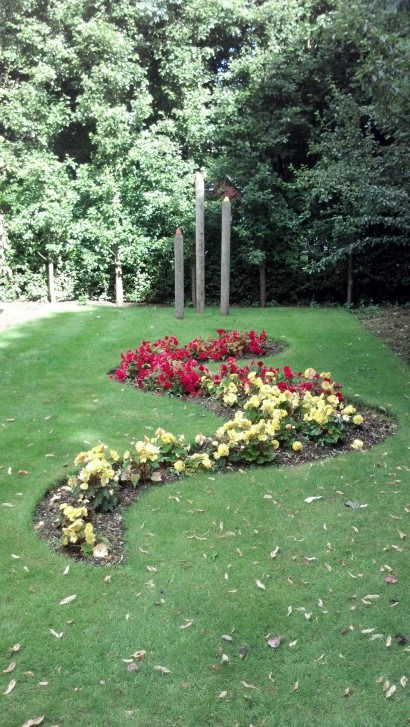 Red and yellow flowers set into an wave shaped border cut into a lawn