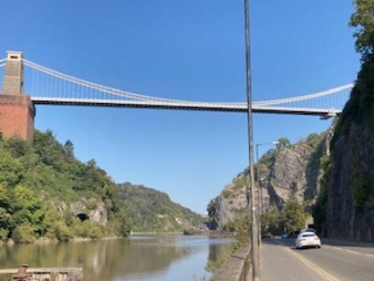 A suspension bridge, spanning a pretty river