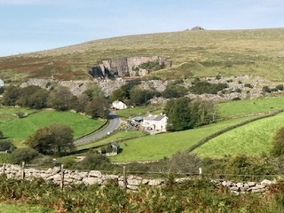 A look down over countryside, with a drystone wall in the foreground