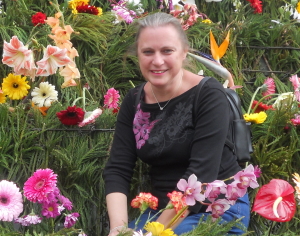 Maxine, surrounded by multicoloured flowers on several levels