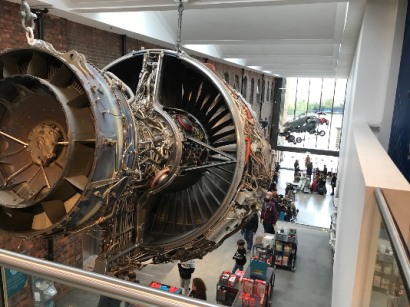 A view down a gallery is dominated by a large turbine engine