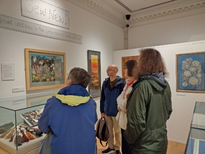 The group admire some of the embroidered artwork on the walls.