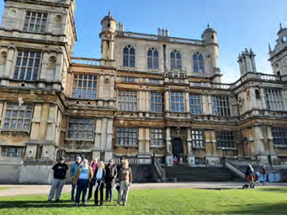 The group standard on the lawn in front of Wollaton Hall on a sunny day