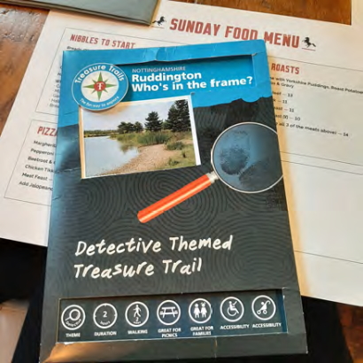 The trail guide booklet on top of the pub's Sunday menu