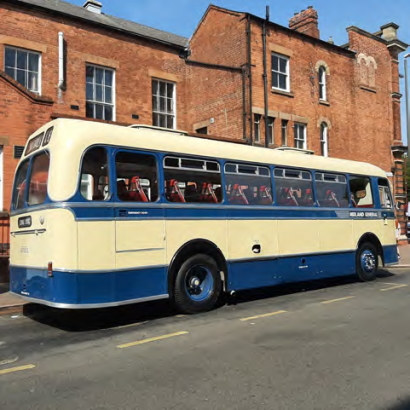 A blue and yellow bus of maybe about 1960s vintage