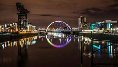 A colourful scene looking along the river with building lights reflected in the water
