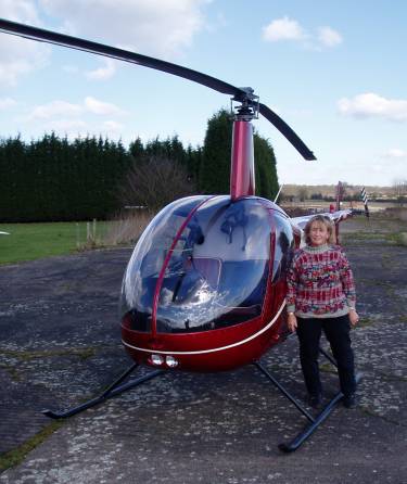 Picture of Helen Kraser alongside her helicopter.
