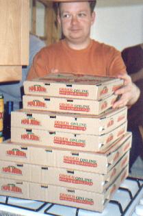 Picture of Andy behind a large pile of pizza boxes