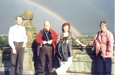 Picture of a members on Southwell Minster roof with a double rainbow behind them