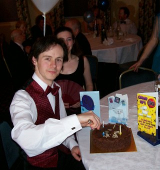 Picture of Iain Benson cutting his birthday cake.