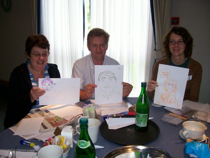 Three members show off their cartoon artwork.